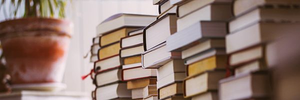 Piles of books stacked on a carpet